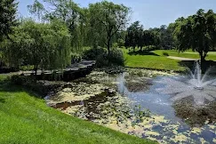 Outdoor garden ceremony at Talamore Weddings in Ambler, Pennsylvania, pergola by the pond at sunset