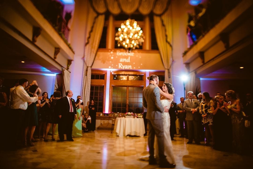 Indoor wedding reception at Talamore Weddings featuring a couple's first dance, elegant chandelier, and guests celebrating in a beautifully decorated ballroom.